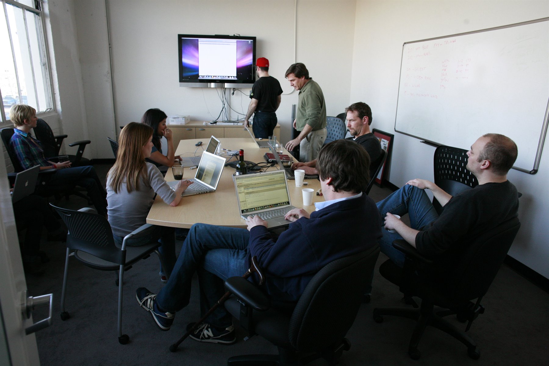 Team meeting with laptops in a conference room, representing founder preparation and investor readiness.